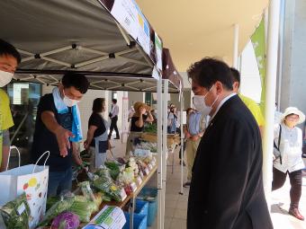 所沢産野菜の出店ブースを見る市長