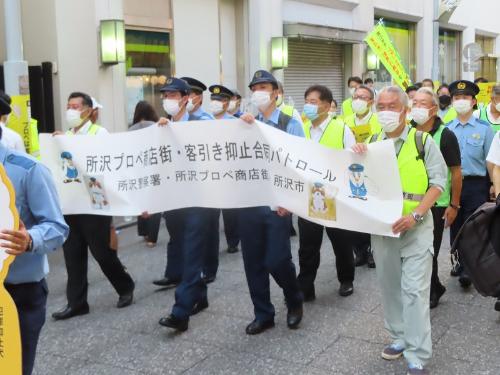 プロぺ通りを所沢警察署や商店街振興組合の皆さんとともに行進する市長の様子