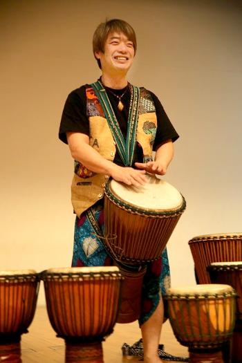 ジャンベを演奏する石川さんの写真