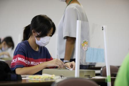 石を削ってまが玉を作る子ども