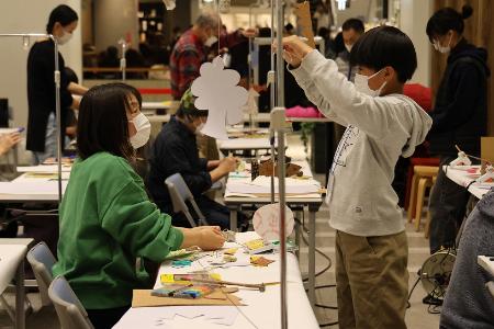 作った作品をひもでつるしている子どもの様子