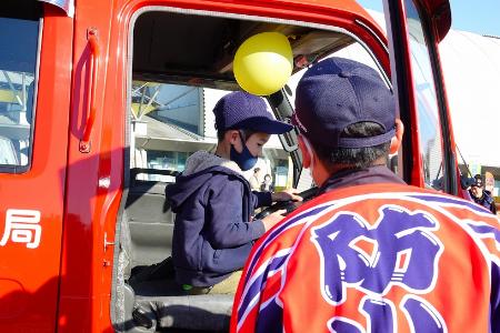 消防車両が展示されたコーナーで、運転席に乗る子ども