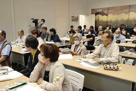 研修室の椅子に沢山の人が座っている