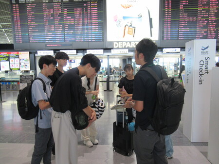 空港で出発の準備をする学生たち