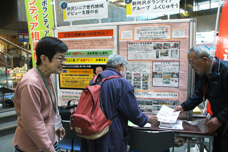 団体の活動を紹介するチラシを来庁者へ渡している画像