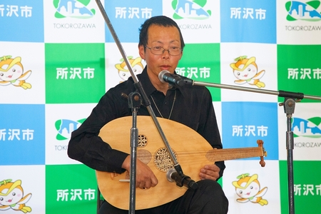 ギターのような民族楽器で弾き語る男性
