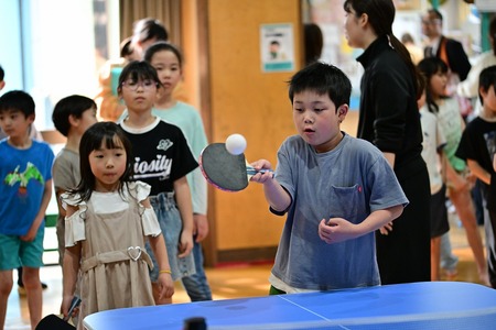 男の子が卓球のボールを打ち返す瞬間の画像