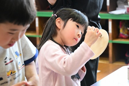 ラケットにスタンプでデコレーションする女の子の様子