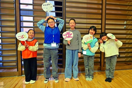 応援うちわを持ってポーズをとるこばと児童館の児童たち