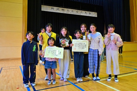 すみれ児童館の参加児童と職員が賞状と盾を持って集合写真を撮っている