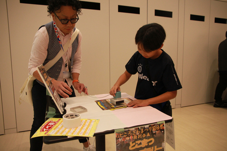 とこまつスタンプラリーでスタンプを押すこども