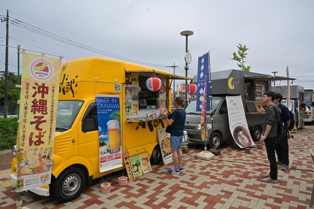 キッチンカーが並び沖縄料理そばののぼりが立っている