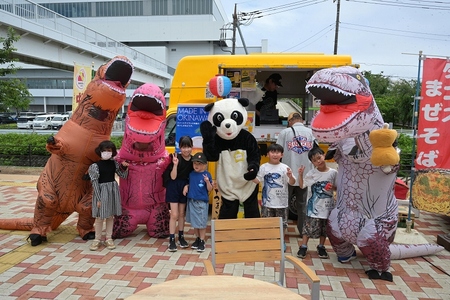パンダや恐竜の着ぐるみと並んで写真を撮る子供たち