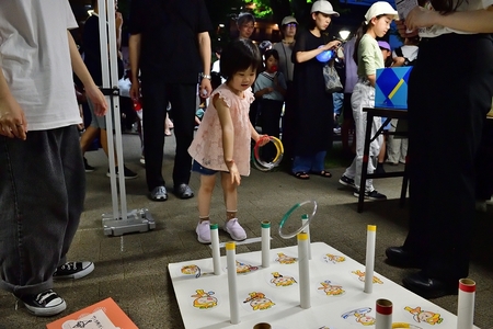輪投げゲームをする女の子の画像