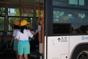 バスの入口でカードリーダーにタッチするこども