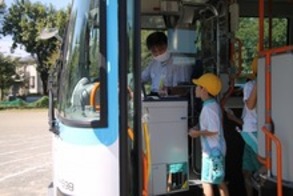 バスの出口でカードリーダーにタッチするこども