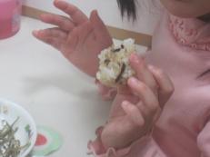 子どもがおにぎりを食べている写真