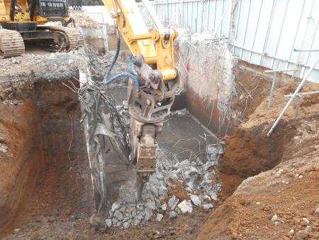 排水処理施設の地下の部分をショベルカーで解体している様子の写真