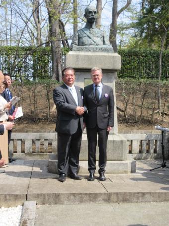 フォール大佐像前でフランス大使と握手する市長の写真