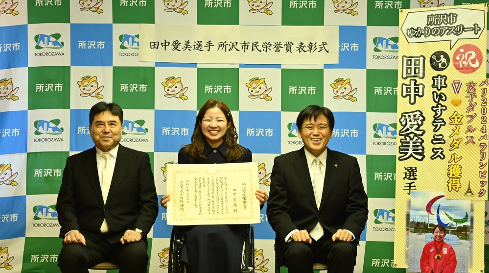 田中選手が表彰状を手に集合写真を撮影しているところ
