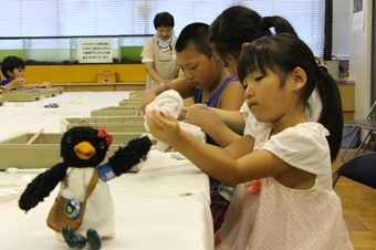 まが玉を作っている子供の写真