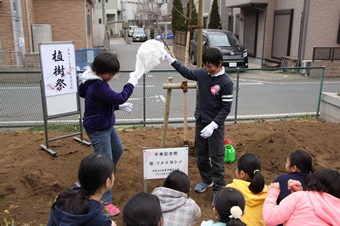 卒業記念樹のプレートを披露する瞬間の写真