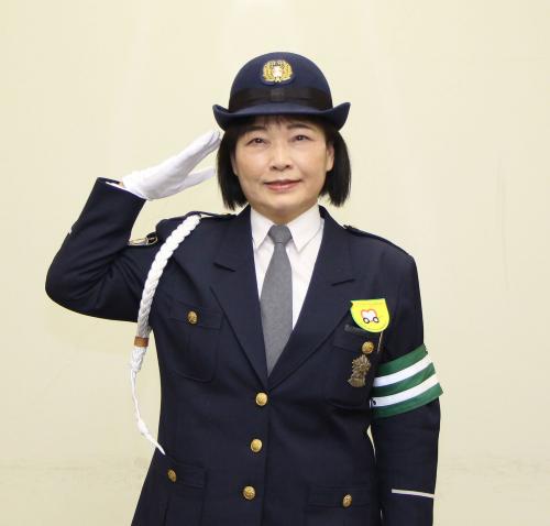 交通指導員の制服姿で敬礼する高柴佳子さん