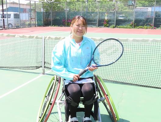 たかむろさんがラケットを持ってポーズを決めている写真