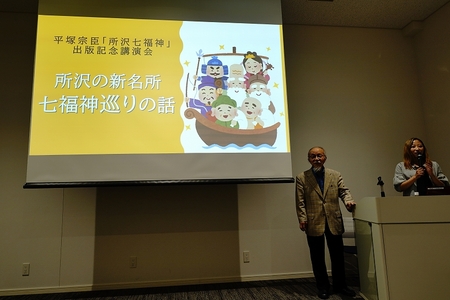 講演会のパワーポイントのスライドの前に立つ平塚宗臣氏