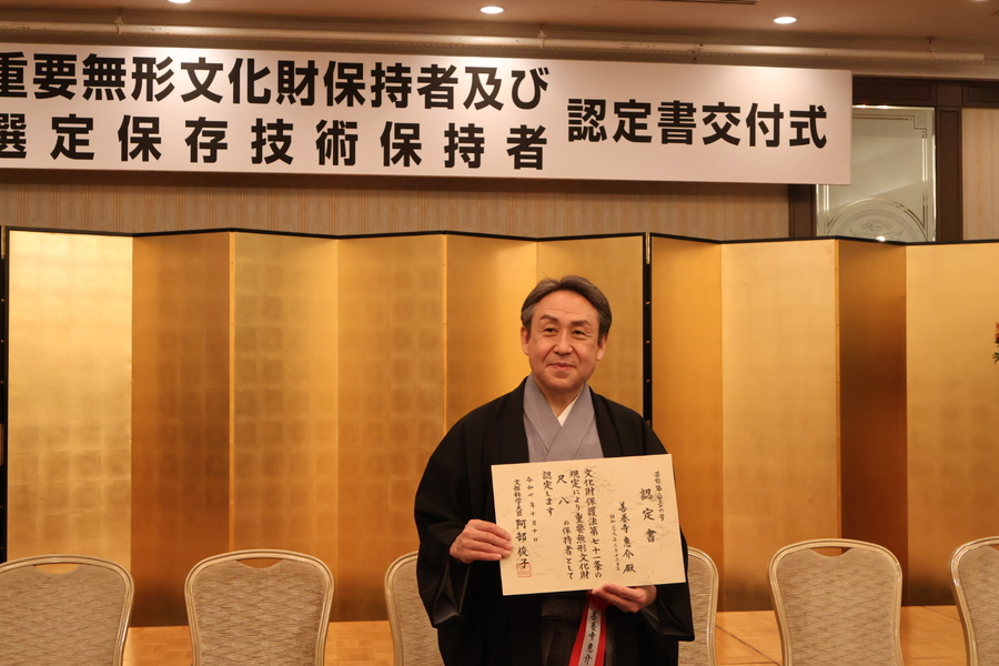 認定証を持つ善養寺恵介氏の写真