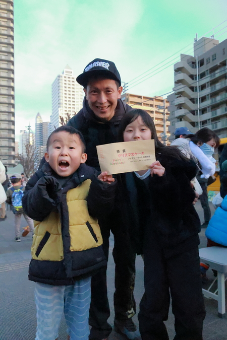 大抽選会でクリスマスケーキが当選した親子の様子