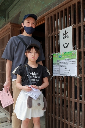 クイズの貼り紙の前に立つ男の人と女の子