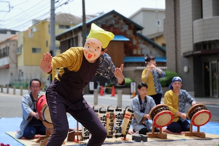 重松流祭囃子にあわせて踊るお面をかぶった人