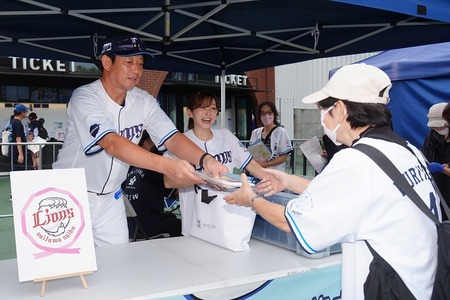 監督が周知グッズを手渡している画像