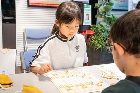中学年の男女2人が対局している様子